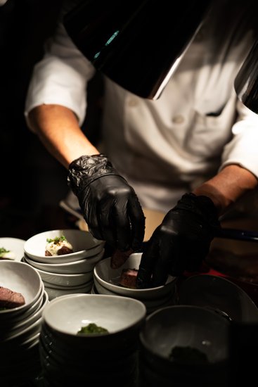 A chef prepares small plates during dinner service
