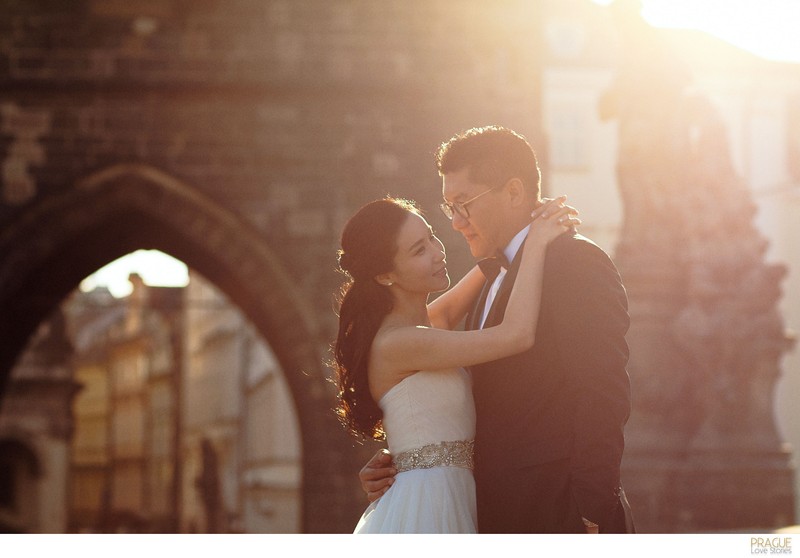 Elegant couple enjoying sunrise on the Charles Bridge