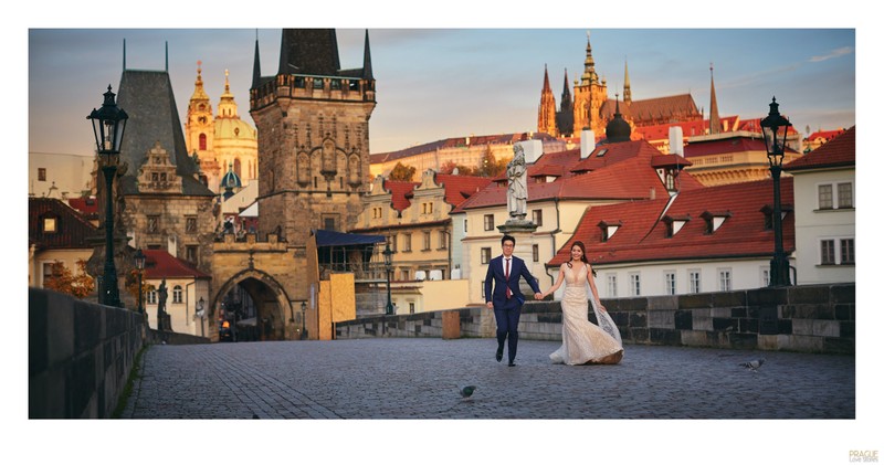 Running across the Charles Bridge hand in hand