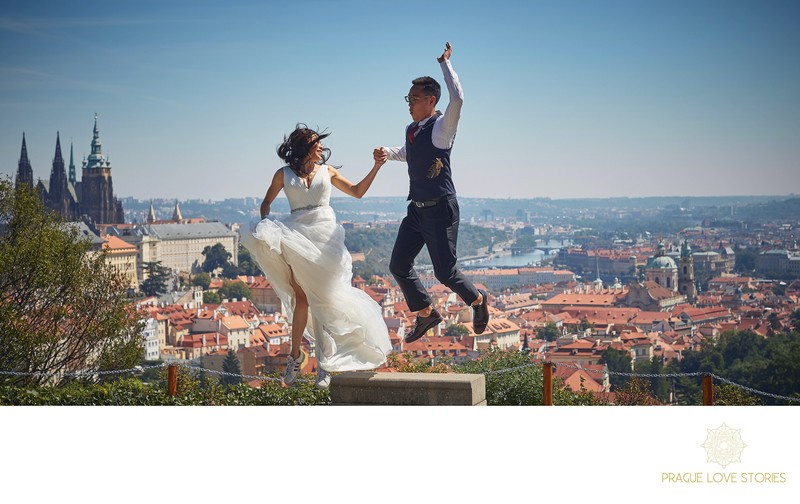bride & groom jump for joy above Prague