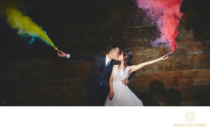 bride & groom kiss as they hold smoke grenades