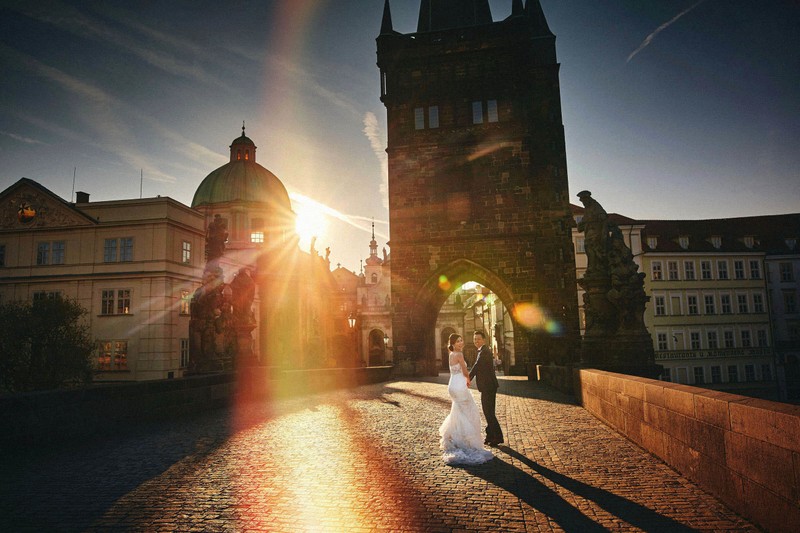 happy couple running in sunshine Charles Bridge