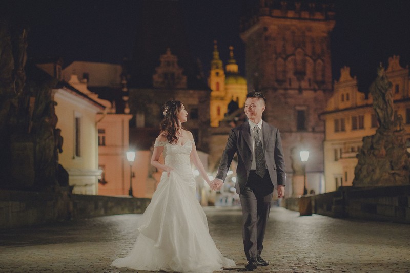 Hong Kong Newlyweds Walking Across Prague Charles Bridge At Night