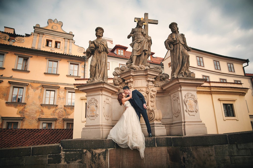 Dipping his bride atop the Charles Bridge