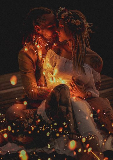 Tattooed Couple Embracing Amid Fairy Lights in Bohemia