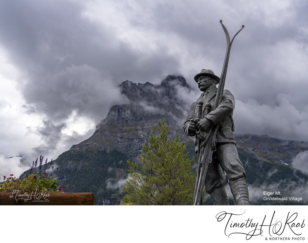 Statue of an early skier in Grindelwald village centre, the Eiger mountain in the background.
