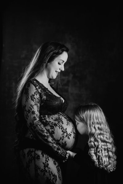 Daughter Kissing Pregnant Mother During Maternity Photos