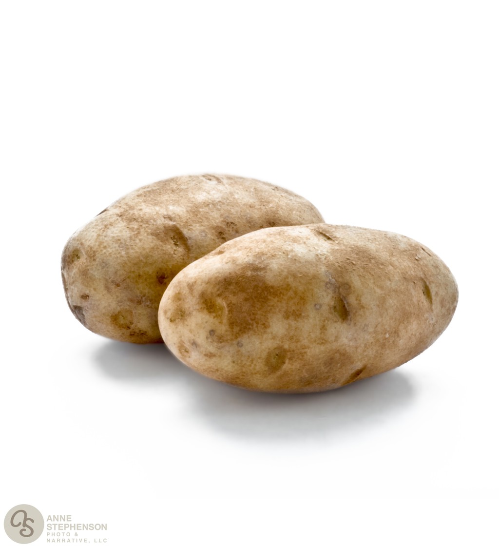 Two russet baking potatoes on white background
