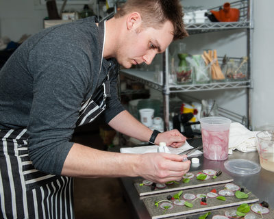 Chef applies microgreens with tweezer