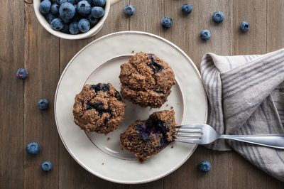 blueberry muffins on a plate with napkin and fork