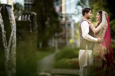 slightly blurred outdoor shot of south asian bride and groom