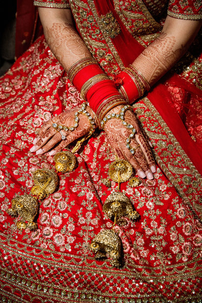 close up of south asian brides henna and bangle addorned hands 